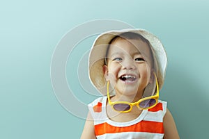 Asian boy with hat and yellow sunglasses laughing