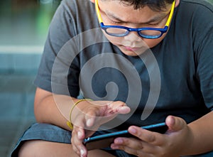 Asian boy have a serious face while playing game on smartphone