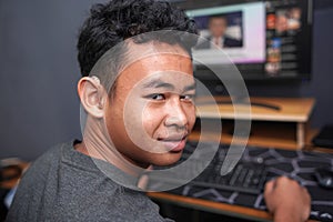Asian boy with hearing aid device using computer