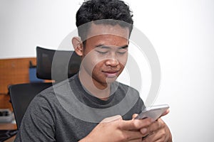 Asian boy with hearing aid device using phone