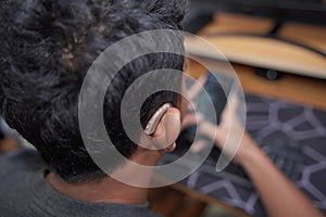 Asian boy with hearing aid device using phone
