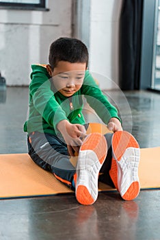 Asian boy holding ball and stretching