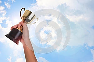 Asian boy holding a gold trophy cup for first place champion award on white background.