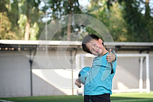 Asian boy holding soccer ball, gesturing thumb up success sign, Kid in soccer uniform at Training Session, Soccer Drills for Kids