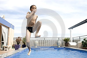 Asian boy jumpin into swimming pool