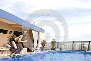 Asian boy jumpin into swimming pool