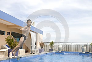 Asian boy jumpin into swimming pool