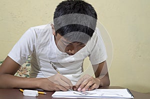 Asian boy learning and practicing to draw 3D shapes on drawing notebook