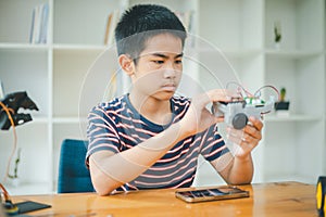 Asian boy learning and studying the work of technology robots.homeschool and science for tech project. playing childhood kids