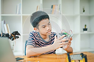 Asian boy learning and studying the work of technology robots.homeschool and science for tech project. playing childhood kids