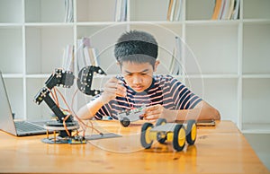 Asian boy learning and studying the work of technology robots.homeschool and science for tech project. playing childhood kids