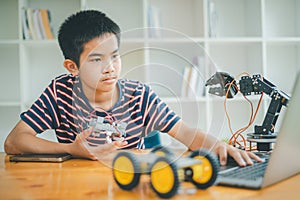 Asian boy learning and studying the work of technology robots.homeschool and science for tech project. playing childhood kids