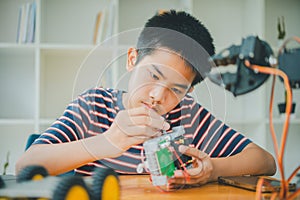 Asian boy learning and studying the work of technology robots.homeschool and science for tech project. playing childhood kids