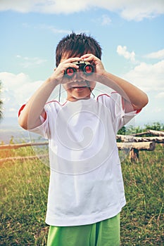 Asian boy looking through a telescope. Child relaxing holiday. V