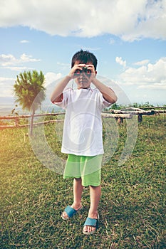 Asian boy looking through a telescope. Child relaxing holiday. V