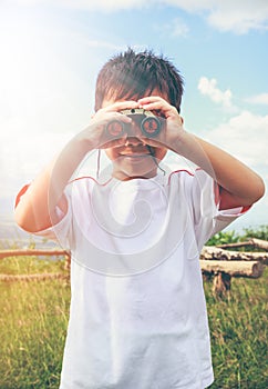 Asian boy looking through a telescope. Child relaxing holiday. V