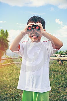 Asian boy looking through a telescope. Child relaxing holiday. V