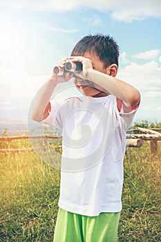 Asian boy looking through a telescope. Child relaxing holiday. V