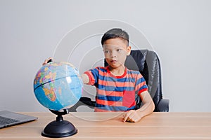 Asian boy looking at world map