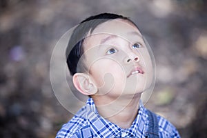 Asian boy lookingup outdoors photo
