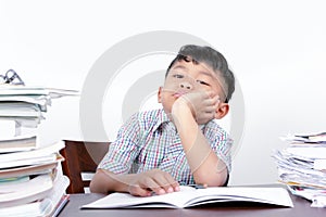 Asian boy looks bored studying on a desk and white background