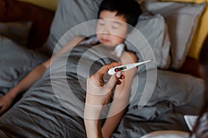 Asian boy lying in bed while