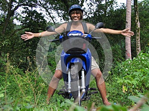 Asian boy on motorcycle in jungle