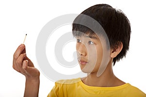 Asian boy observing burned out match