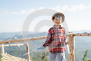 Asian boy play and enjoy his bubbles soap toy on camping tent area