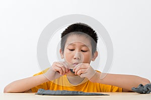 Asian boy playing clay at home.