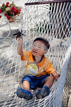 Asian boy playing with toy bug