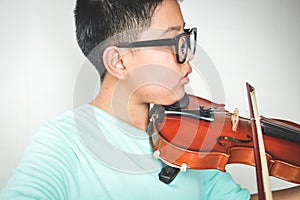 An Asian boy is playing the violin.