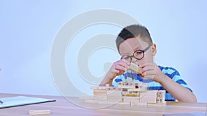 Asian boy playing with a wooden puzzle