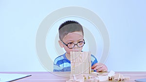 Asian boy playing with a wooden puzzle