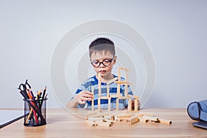 Asian boy playing with a wooden puzzle