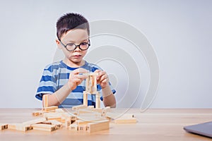 Asian boy playing with a wooden puzzle