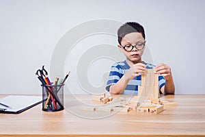 Asian boy playing with a wooden puzzle