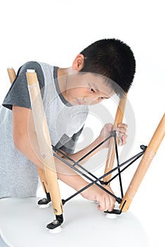 Asian boy repair white chair isolated on white