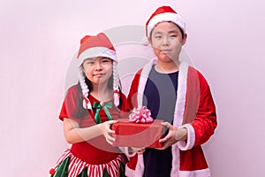 Asian boy in santa clothes and girl in Elf clothes holding gift. Merry christmas