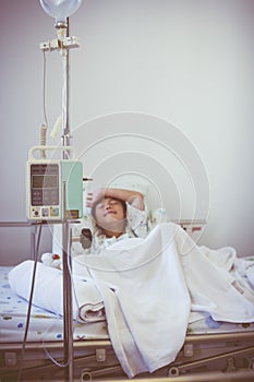 Asian boy sleeping on sickbed with infusion pump intravenous IV