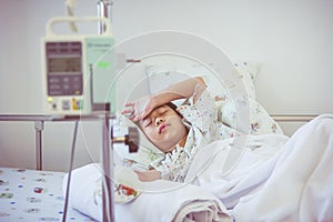 Asian boy sleeping on sickbed with infusion pump intravenous IV