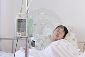 Asian boy sleeping on sickbed with infusion pump intravenous IV