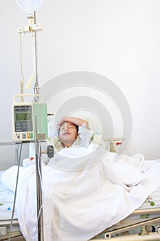 Asian boy sleeping on sickbed with infusion pump intravenous IV