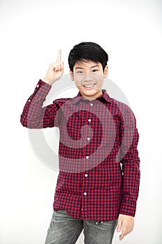 Asian boy smiling and pointing finger up .