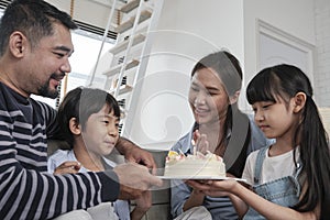 Asian boy is surprised with birthday cake and celebrates party with family