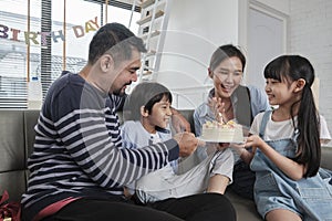 Asian boy is surprised with birthday cake and celebrates party with family