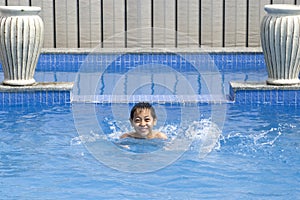 Asian boy is swimming in pool