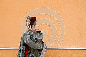 Asian boy talking on mobile phone while standing outdoors