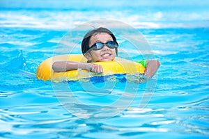 Asian boy in tube learning to swim