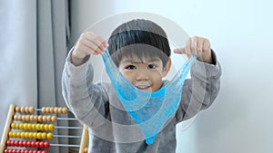 Asian boy using scissors to cut paper along lines Learning outside the classroom